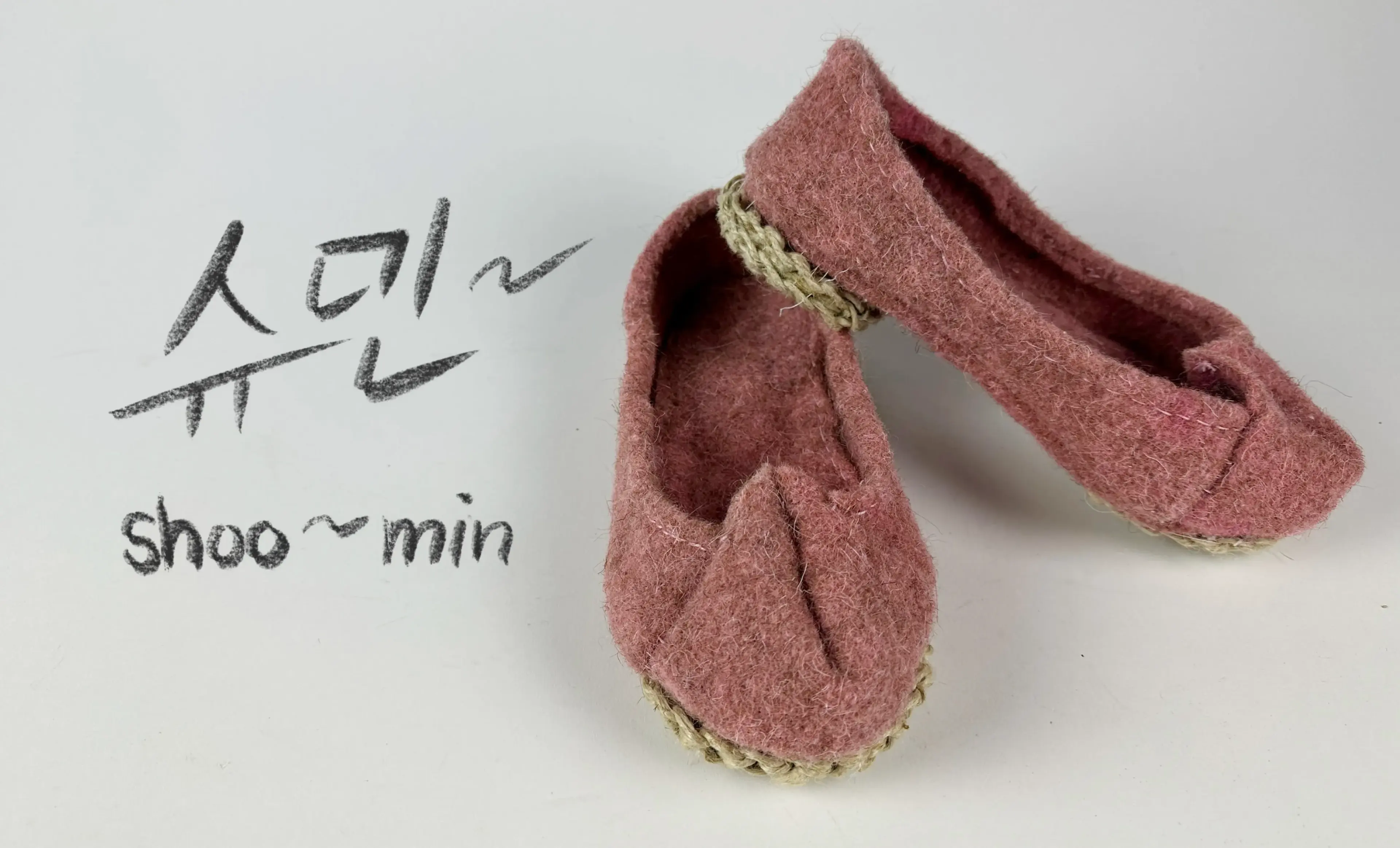 Pink Korean-inspired shoes designed by Sumin are displayed prominently on the right. On the left, it reads 슈민~ above Shoo~min, in digital charcoal-looking lettering.